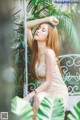 A woman in a white dress sitting on a bench.