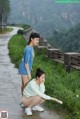 A couple of women standing next to each other on a road.