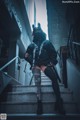 A woman in a black outfit is sitting on some stairs.