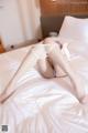 A woman laying on top of a bed in white stockings.