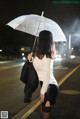 A woman walking down the street holding an umbrella.